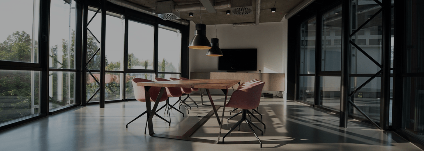 Image of a spacious office with a large wooden table and chairs in the centre