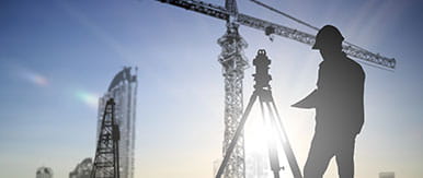 silhouette black man survey and civil engineer stand on ground working in a land building site over Blurred construction worker on construction site.