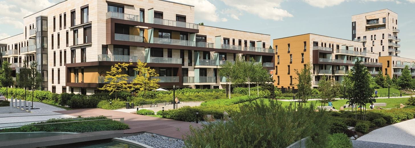 Vista of modern housing block in front of greenery and man-made lake